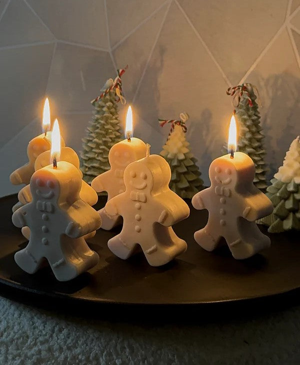 Brandende Gingerbread kaarzen met op de achtergrond kerstboom kaarzen